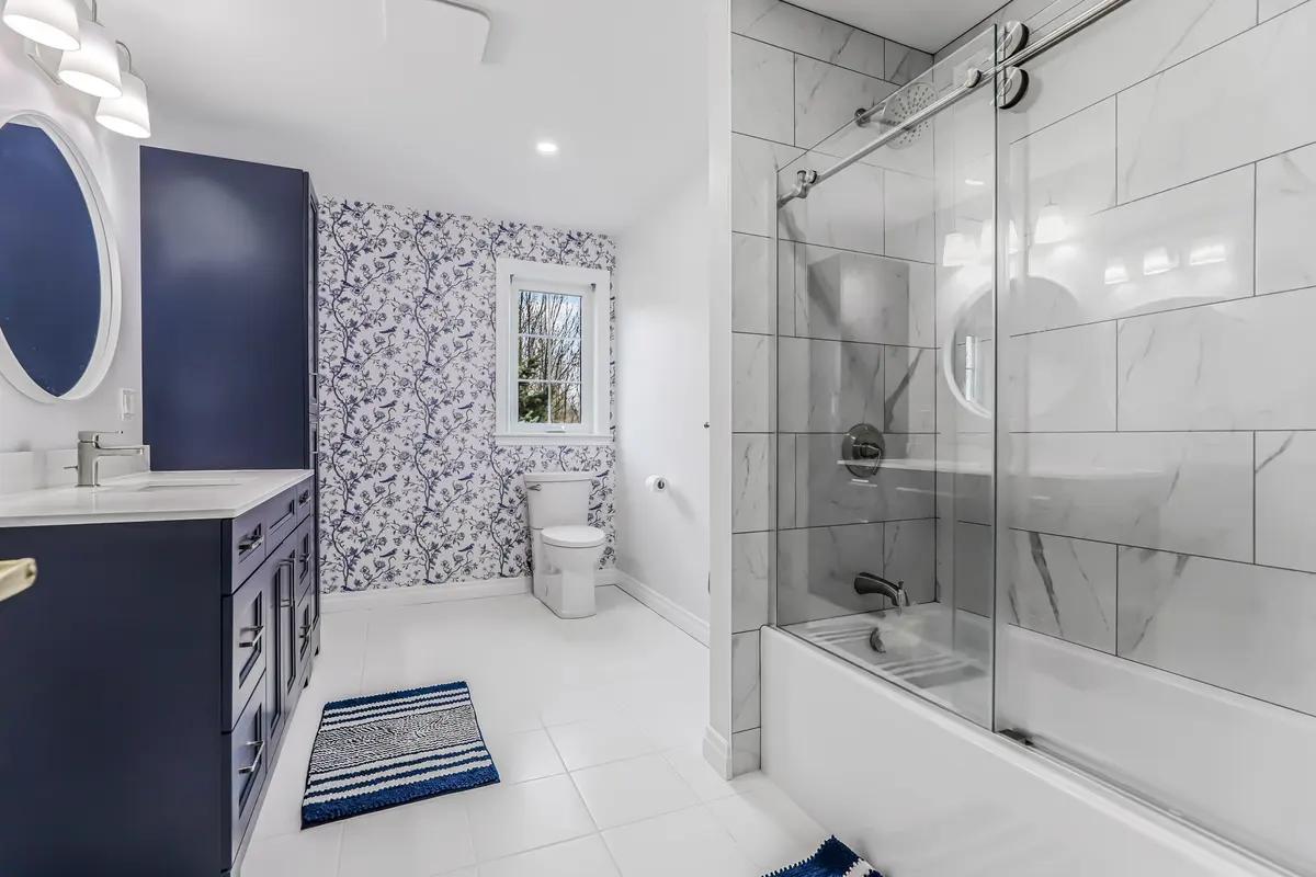 A blue painted vanity coordinated with warm metal, tile and wall finishes.