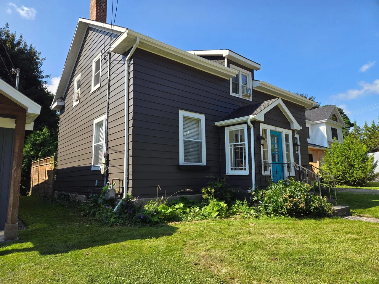 Grey siding, white trim and a blue entry door.